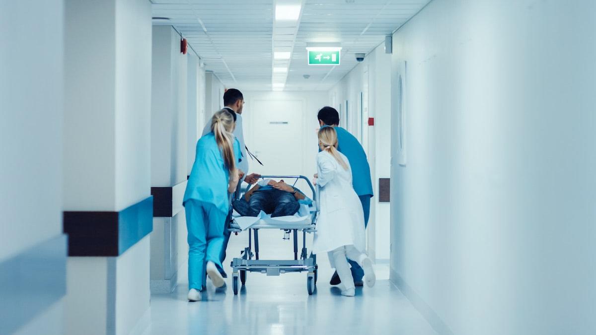 Nurses push patient in hospital hallway